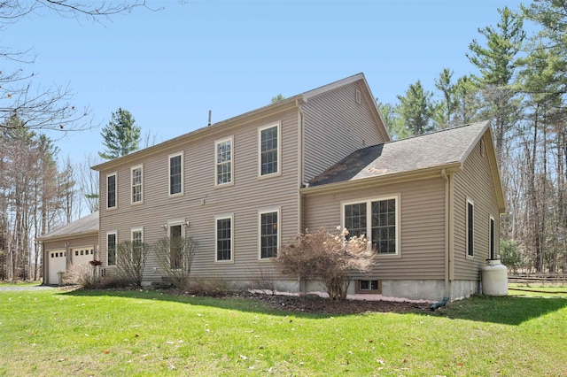 back of property with an attached garage and a yard