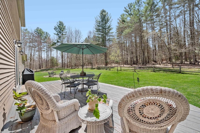 deck featuring a lawn and outdoor dining space