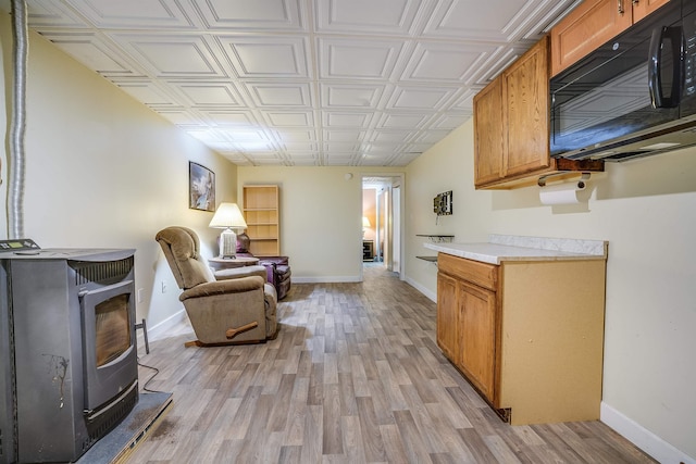 interior space with light countertops, black microwave, brown cabinetry, and light wood-style floors