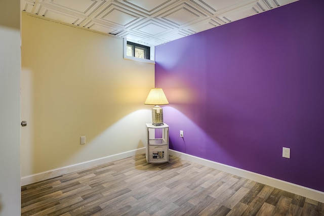 interior space with baseboards, an ornate ceiling, and wood finished floors