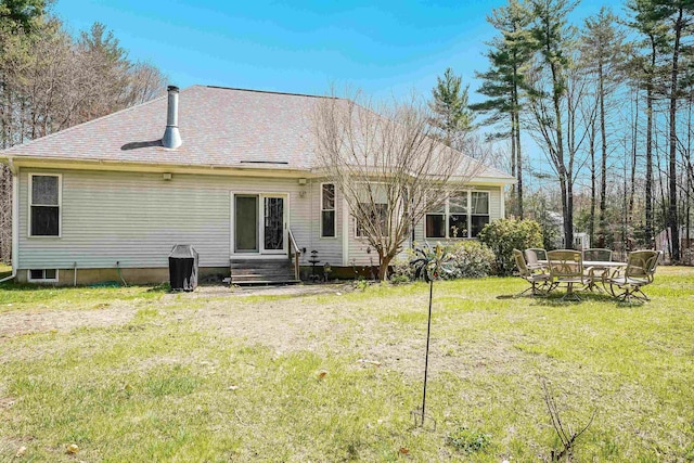 rear view of property with a shingled roof and a yard