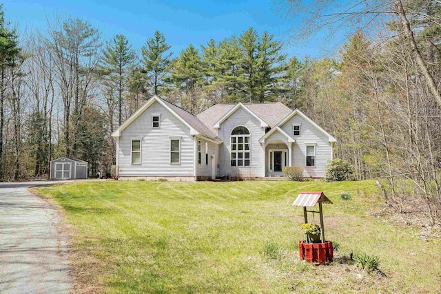 view of front of house featuring a storage shed, an outbuilding, driveway, and a front lawn