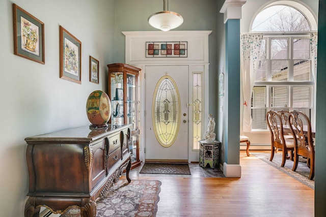 entrance foyer featuring baseboards, wood finished floors, and a baseboard radiator