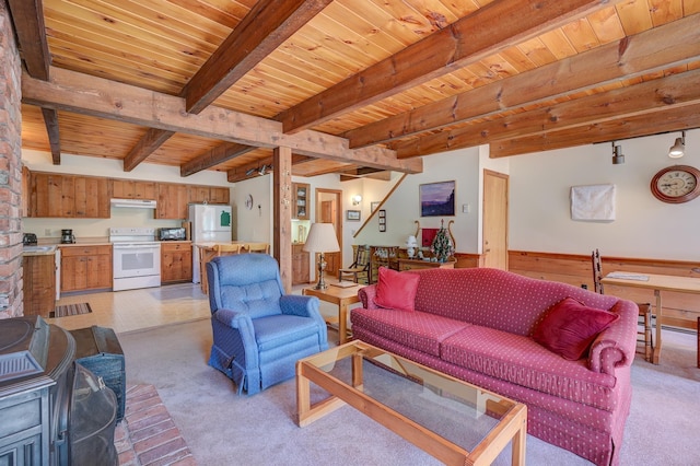 living area featuring wood ceiling, beamed ceiling, a wood stove, and light colored carpet
