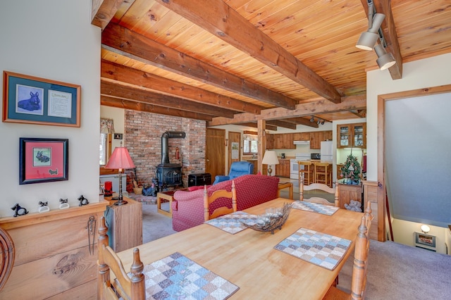 carpeted dining space with beamed ceiling, wooden ceiling, and a wood stove