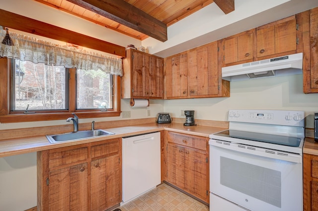 kitchen with a sink, white appliances, light countertops, under cabinet range hood, and beamed ceiling