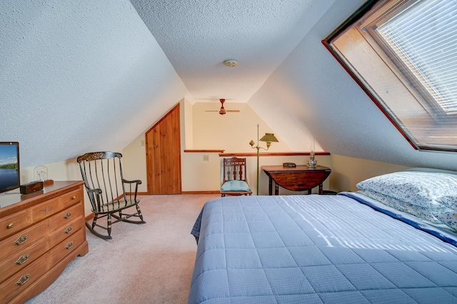 bedroom with light colored carpet, baseboards, a textured ceiling, and lofted ceiling