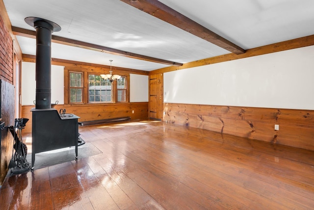 interior space featuring wooden walls, a wood stove, hardwood / wood-style flooring, and beam ceiling