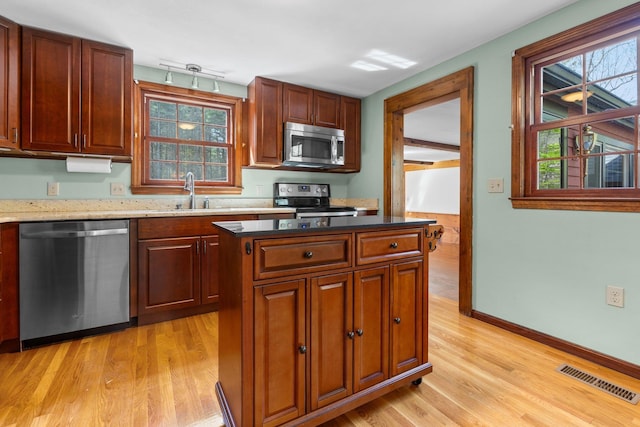 kitchen with visible vents, a sink, light wood-style flooring, and appliances with stainless steel finishes