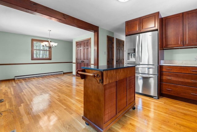 kitchen featuring a center island, stainless steel fridge with ice dispenser, a baseboard radiator, light wood finished floors, and a chandelier
