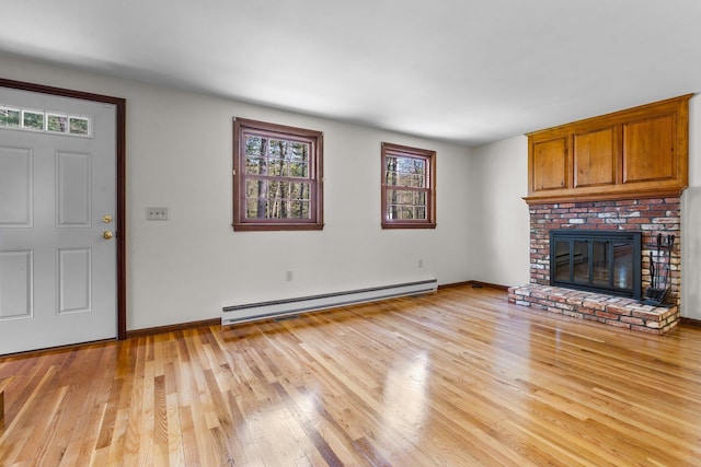 unfurnished living room featuring baseboards, a fireplace, a baseboard heating unit, and light wood-style flooring