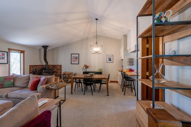 interior space with vaulted ceiling, light colored carpet, and a wood stove