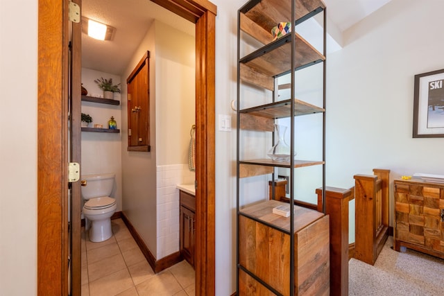 bathroom with toilet, tile patterned floors, and baseboards