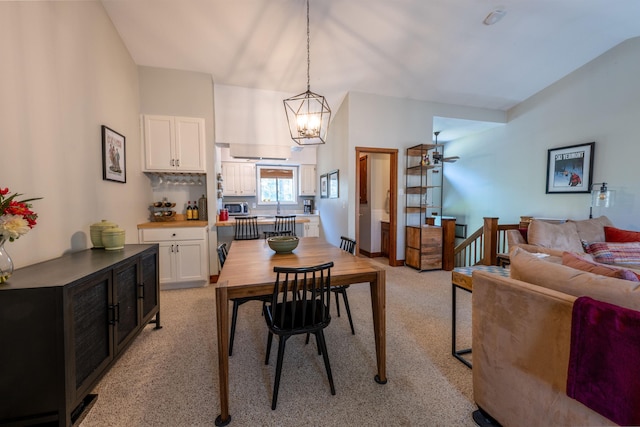 dining room with a notable chandelier and light colored carpet