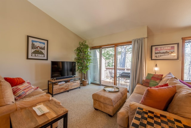 living area with baseboard heating, vaulted ceiling, a wealth of natural light, and carpet