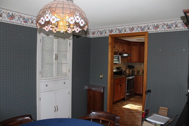 dining room with wallpapered walls and a notable chandelier