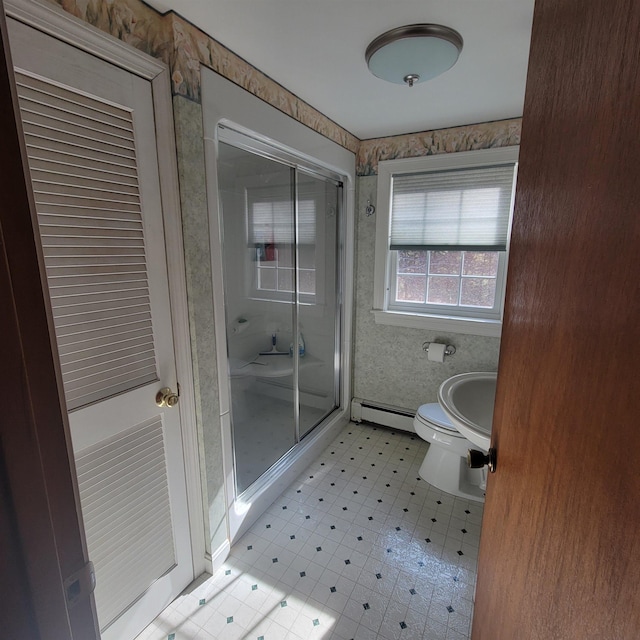 full bathroom featuring a stall shower, baseboard heating, and toilet