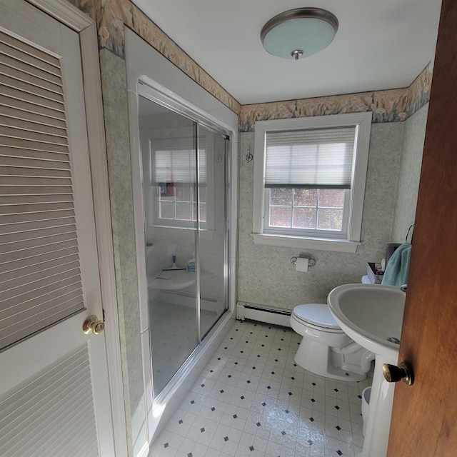 bathroom with a stall shower, tile patterned floors, a baseboard heating unit, toilet, and wallpapered walls