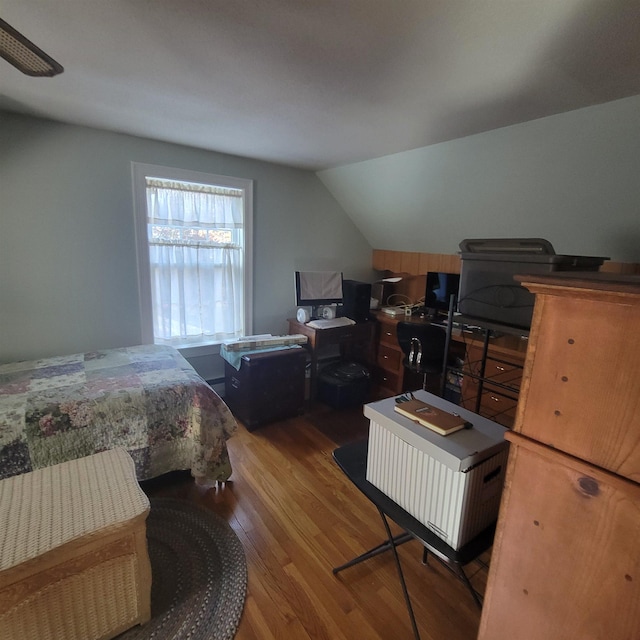 bedroom featuring wood finished floors and vaulted ceiling