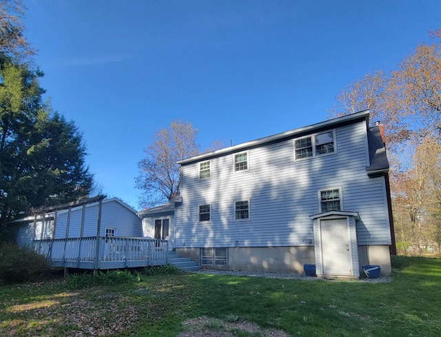 rear view of house with a yard and a deck