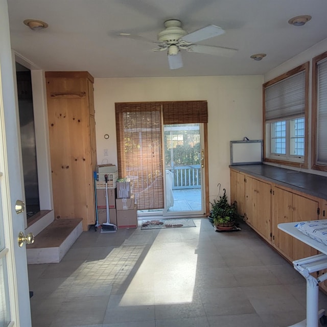 interior space with a ceiling fan, light floors, and a healthy amount of sunlight