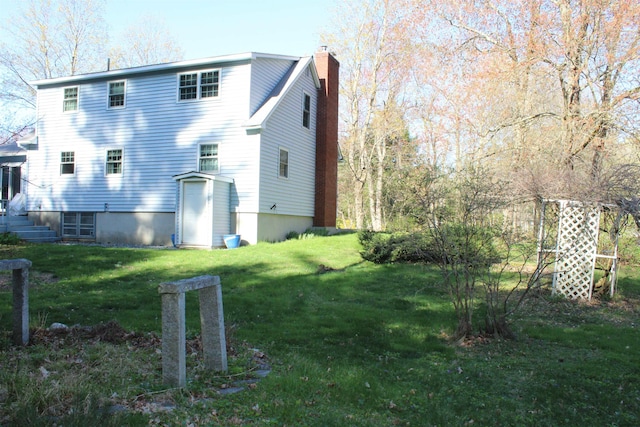 rear view of house with a yard and a chimney