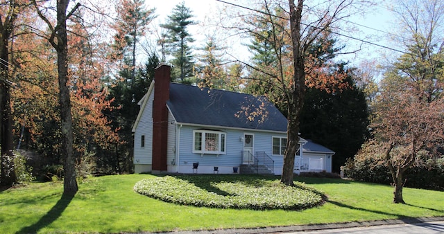 view of front of home with a shingled roof, a front yard, and a chimney