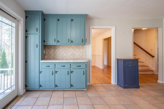 kitchen featuring blue cabinetry, decorative backsplash, and light tile patterned floors