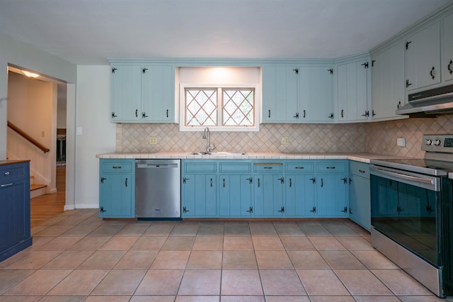 kitchen featuring blue cabinetry, appliances with stainless steel finishes, and a sink