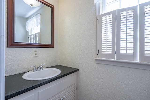 bathroom featuring a textured wall and vanity