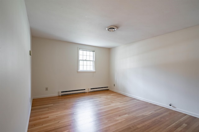 empty room featuring baseboards and light wood finished floors