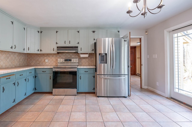 kitchen featuring backsplash, blue cabinets, appliances with stainless steel finishes, and under cabinet range hood