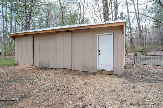view of outbuilding featuring fence and an outdoor structure