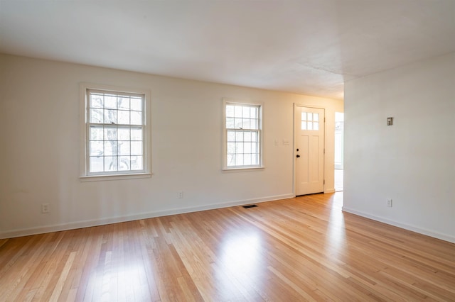 interior space with light wood-type flooring, baseboards, and visible vents