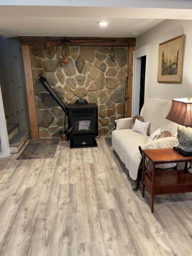 living room with a wood stove and wood finished floors
