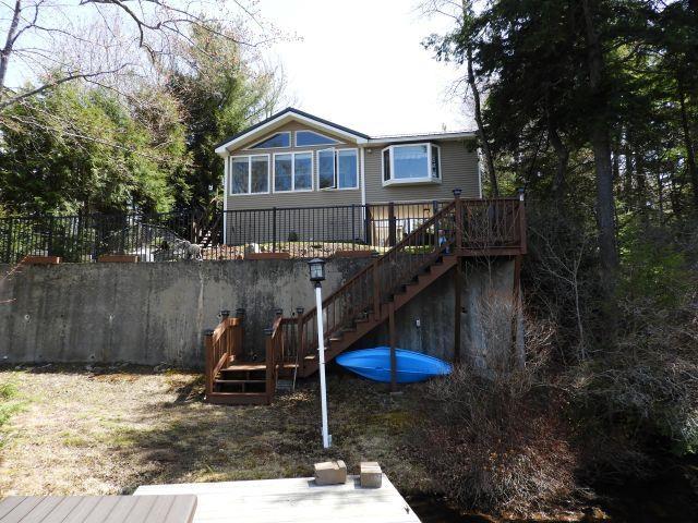 rear view of house with stairs, a wooden deck, and fence