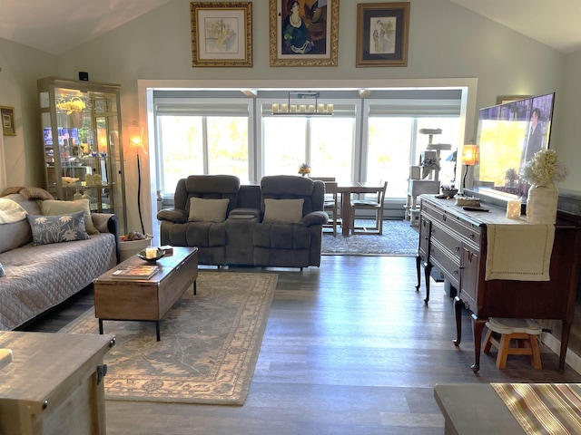 living area with a healthy amount of sunlight, wood finished floors, and lofted ceiling