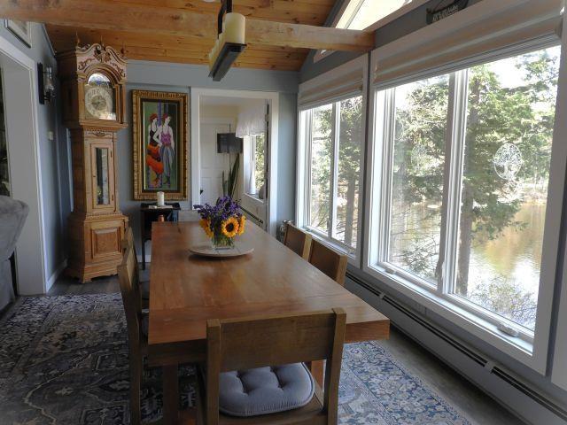 dining room with a baseboard radiator, lofted ceiling with beams, a wealth of natural light, and wooden ceiling