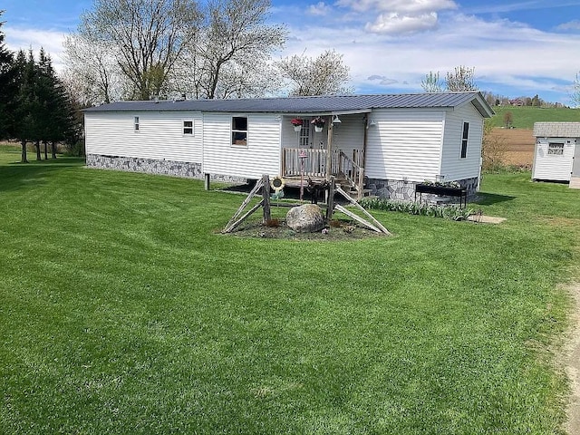 rear view of property with a yard and metal roof