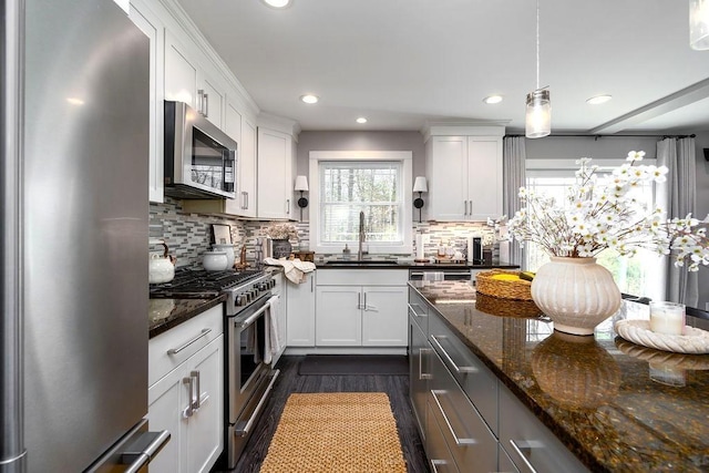 kitchen with backsplash, stainless steel appliances, a wealth of natural light, and a sink
