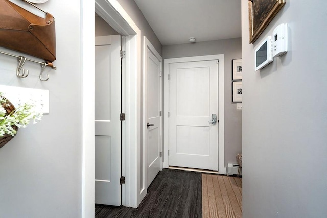 corridor with baseboard heating and dark wood-style flooring