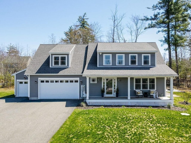 view of front of house featuring covered porch, aphalt driveway, a front yard, and a garage