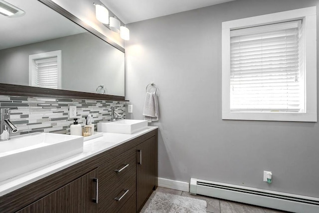 bathroom featuring a sink, tile patterned flooring, a baseboard radiator, and backsplash