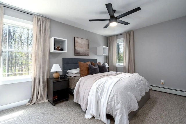 bedroom with baseboards, a ceiling fan, a baseboard heating unit, and light carpet