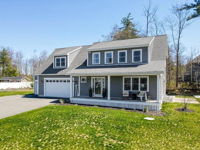 view of front of home featuring a porch, a shingled roof, a front yard, and aphalt driveway