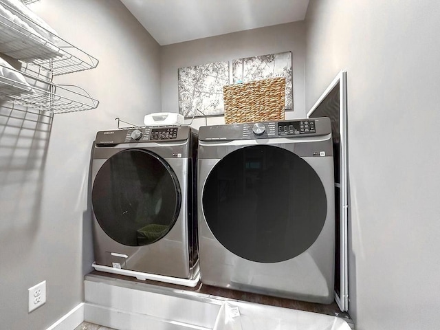 clothes washing area featuring separate washer and dryer, laundry area, and baseboards