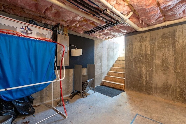 unfinished below grade area featuring water heater and stairway