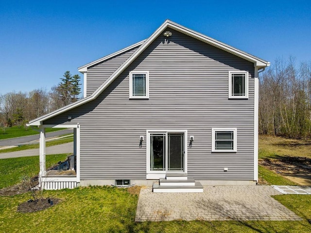 rear view of house featuring a patio area, a yard, and entry steps