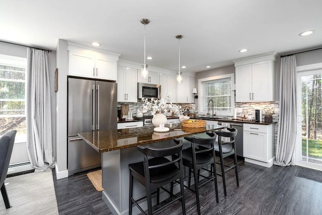kitchen with dark wood-style flooring, stainless steel appliances, a healthy amount of sunlight, and a sink