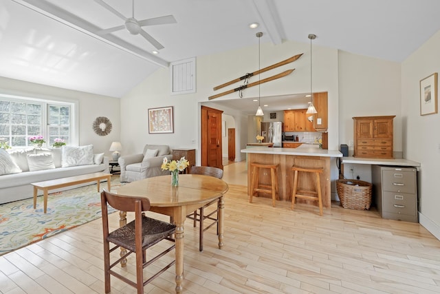 dining area featuring high vaulted ceiling, ceiling fan, beam ceiling, and light wood finished floors